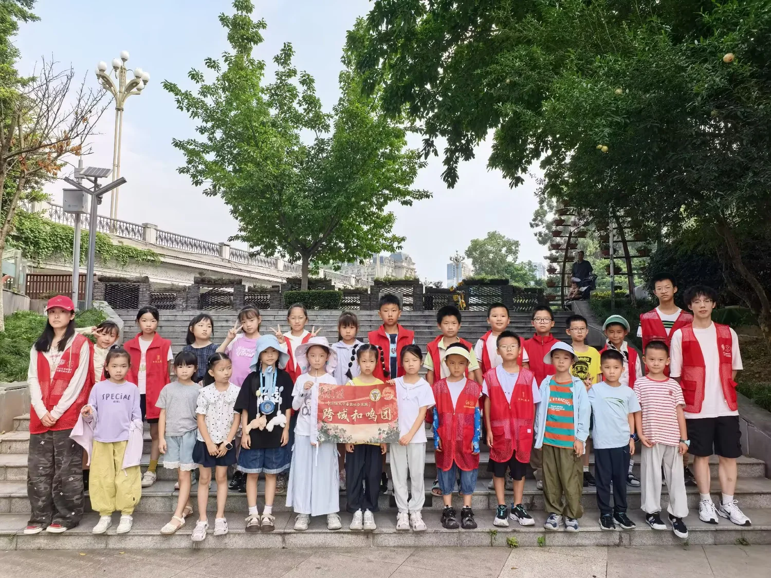 实践团成员与社区青少年在树下合影