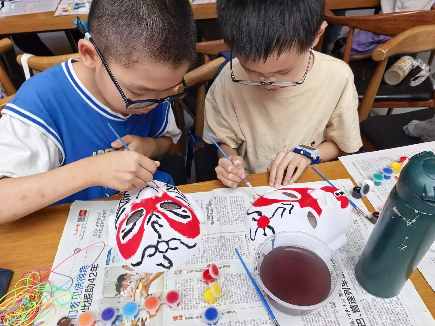 孩子们在桌前绘制中国戏曲脸谱