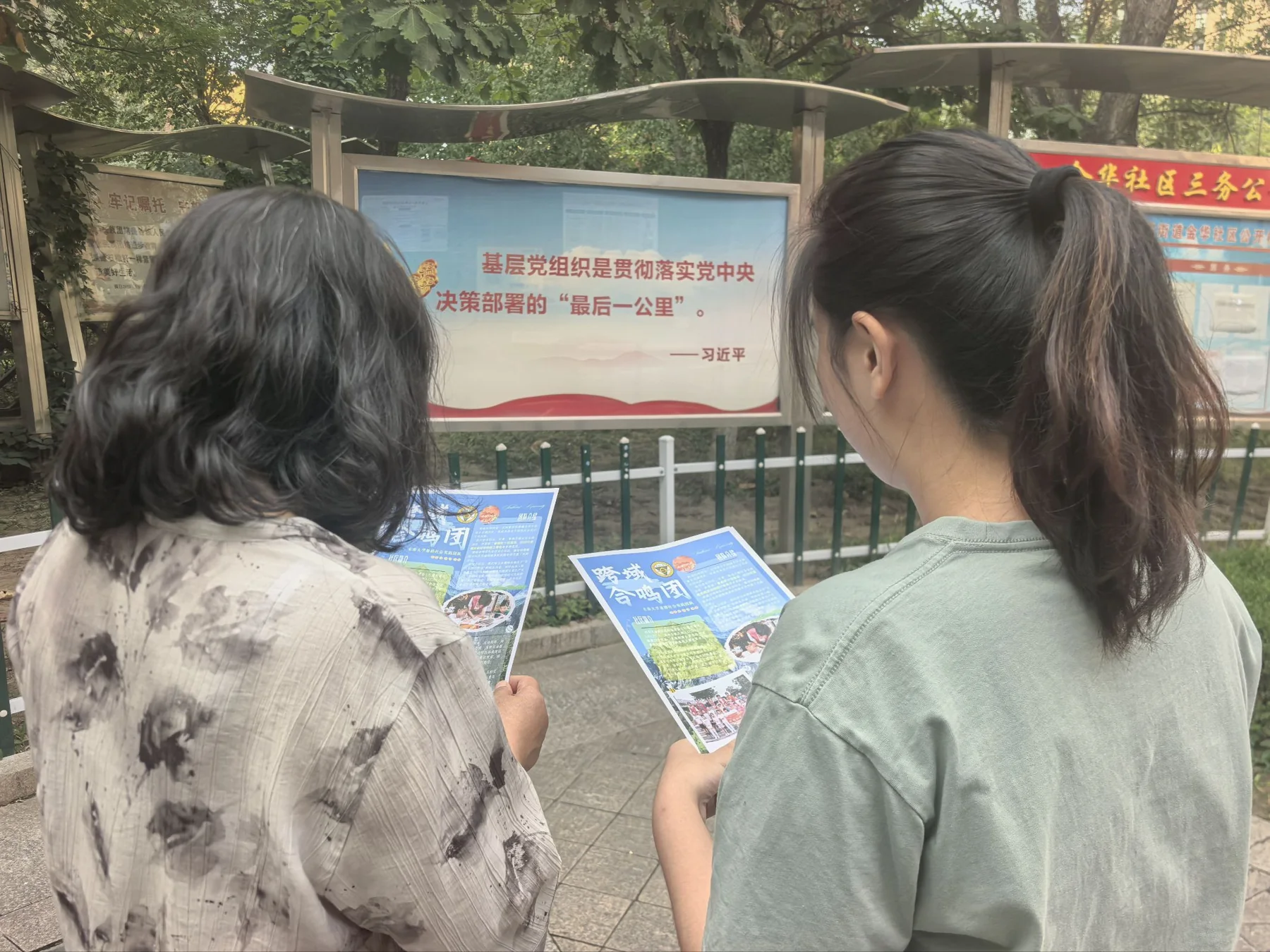 成员在社区公告栏旁向居民介绍实践材料