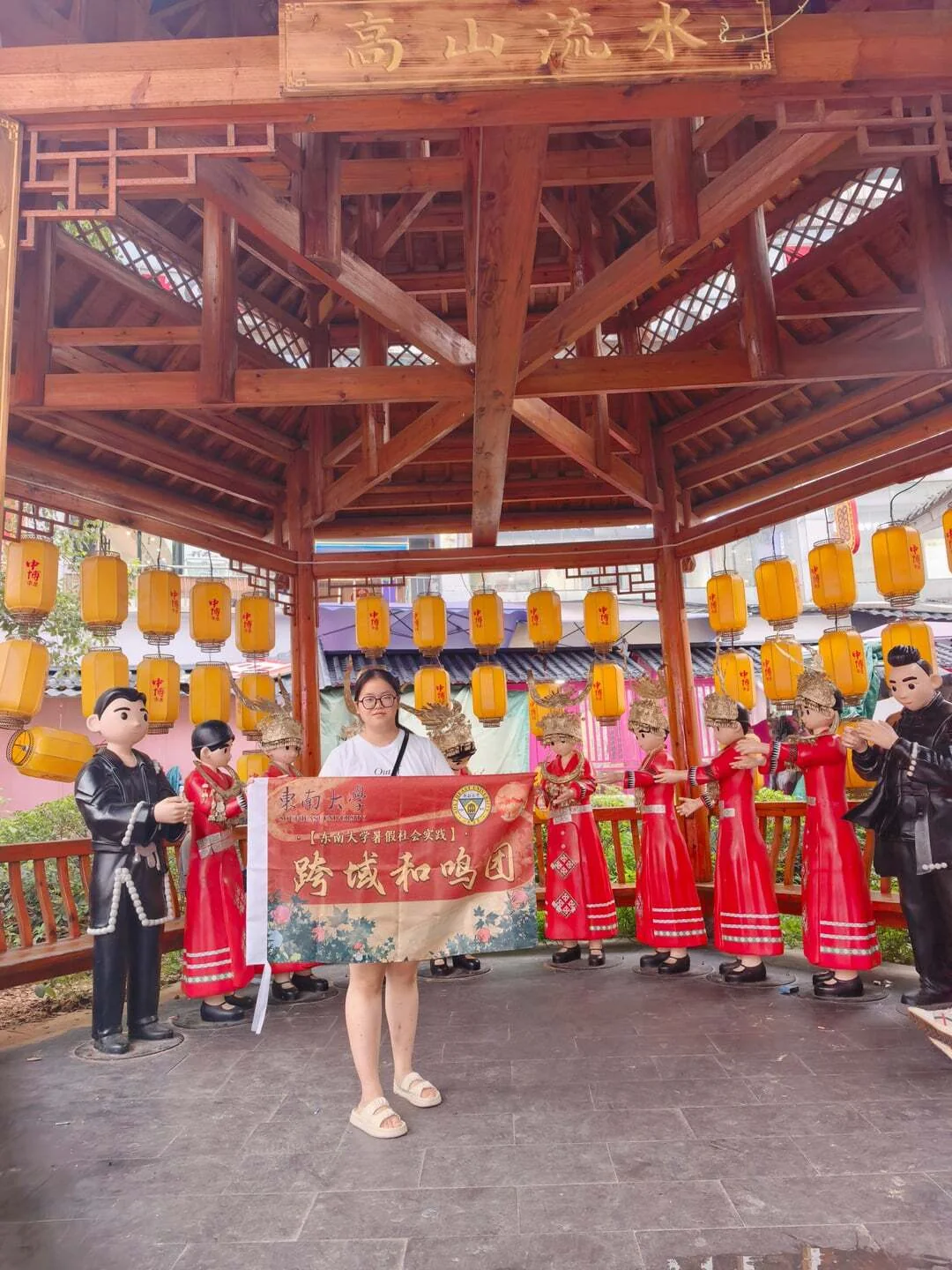 成员在文化展示场景中举起跨域和鸣团旗